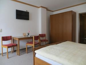 Schlafzimmer mit einem Bett, einem Tisch und Stühlen in der Unterkunft Pension Leppert in Bischofsgrün