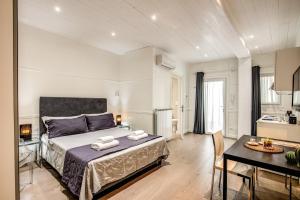 a bedroom with a bed and a table and a kitchen at Colosseo Suite Apartment in Rome