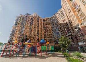 a playground in front of a large apartment building at Fresh Arcadia Apartments in Odesa