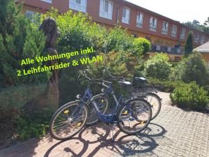 zwei Fahrräder, die vor einem Gebäude geparkt sind in der Unterkunft Ostseepark Zempin in Zempin