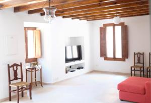 a living room with a red couch and a tv at Can Calet in Marratxí 