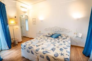a bedroom with a bed with blue and white sheets at Covo dei Saraceni in Polignano a Mare