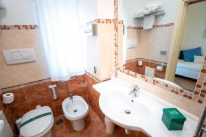 a bathroom with a sink and a toilet and a mirror at Covo dei Saraceni in Polignano a Mare