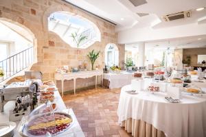 a restaurant with white tables with food on them at Covo dei Saraceni in Polignano a Mare
