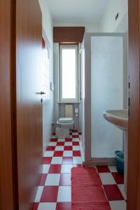 a bathroom with a red and white checkered floor at Albergo La Rovere in Roverbella