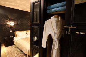 a room with a bed and a robe on a door at Riad Dar Haven in Tamraght Ou Fella