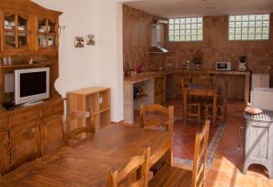 eine Küche mit einem Holztisch und einem TV in der Unterkunft Casa Rural Rosa Blanca in Los Teatinos