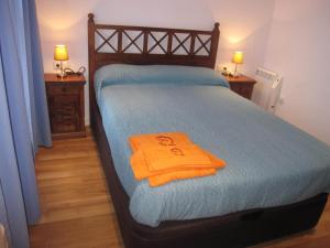 Un dormitorio con una cama con una toalla naranja. en La Casita Azul De Chillaron, en Chillarón de Cuenca