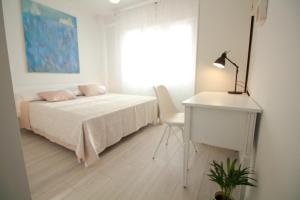 a bedroom with a bed and a desk and a window at Tramontana Leeward - Cozy and charming apartment in beautiful Volosko in Opatija