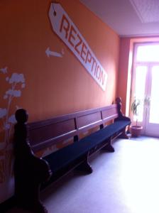 a bench in a room with a retrieval sign on the wall at Hostel Flensburg in Flensburg