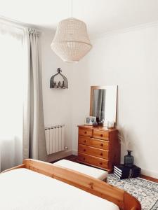 a bedroom with two beds and a dresser and a mirror at Apartamento en el autentico corazón de Mundaka in Mundaka