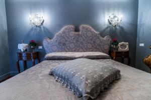 a bedroom with a large bed with a blue wall at Hotel Antica Locanda in Rome