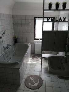 ein Badezimmer mit Badewanne, Toilette und Waschbecken in der Unterkunft Steinmarner Bude in Cuxhaven + 27 Fotos