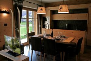 a dining room with a table with chairs and lights at Chalet Remì - Parè in Livigno