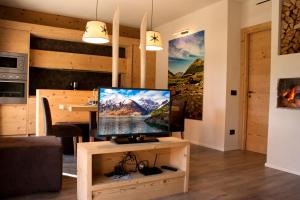 un televisore su un supporto in legno in soggiorno di Chalet Remì - Parè a Livigno