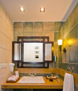 a bathroom with a sink and a mirror at Club Mahindra Sasan Gir in Sasan Gir