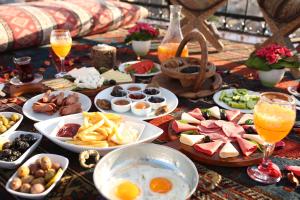 a table topped with plates of food and drinks at Maccan Cave Hotel in Göreme