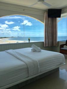 a bedroom with a large bed with a large window at PierView Rooms in Hua Hin