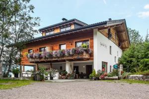 a house with a balcony with flowers on it at Gasleidhof in Funes