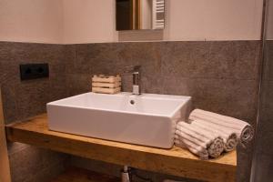 a bathroom with a white sink and towels on a counter at CHALET REMI - DOMIN in Livigno