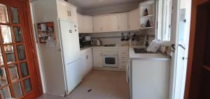 a kitchen with white cabinets and a white refrigerator at Casa Valerie GM003 in Guardamar del Segura