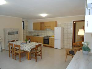 eine Küche mit einem Tisch mit Stühlen und einem weißen Kühlschrank in der Unterkunft Casa Grazia in Crone