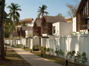 a house with a white fence and palm trees at The Kayana Beach Lombok in Senggigi 