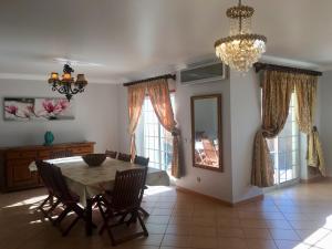 a dining room with a table and chairs and a chandelier at Casa das Figuras in Faro