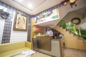 新德里的住宿－Hotel Harsha International，站在餐厅柜台上的人