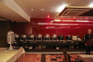 a woman standing in front of a bar with wine glasses at Bizz The Hotel in Rajkot