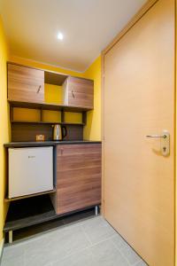 uma cozinha com armários de madeira e uma porta em Casa Livio - Rooms and studios em Como