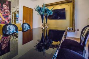 a glass table with a vase with blue flowers on it at LUXURY SUITES - free parking in Drama