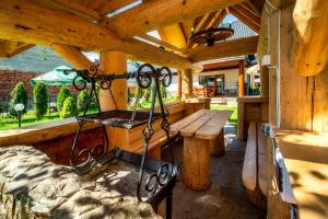 a porch with a wooden bench and a bench swing at Domek u Eli in Czarny Dunajec