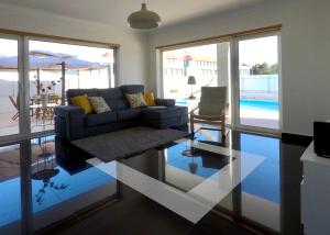 sala de estar con sofá y suelo de cristal en Faulha House,with BBQ and swimming pool, en Sesimbra