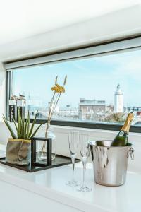a window sill with glasses and a bottle of champagne at Slapen in een Trechter in Harlingen