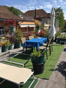 a patio with a blue table and chairs and an umbrella at Chambres papillon in La Neuveville