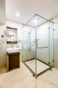 a bathroom with a glass shower and a sink at The Bentley Seaside Boutique Hotel in Chennai