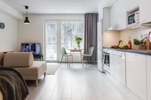 a kitchen and living room with a couch and a table at Spot Apartments Espoo Center in Espoo