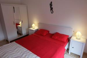 リョレート・デ・マルにあるApartment Iliaの赤いベッド1台、赤い枕2つが備わるベッドルーム1室が備わります。