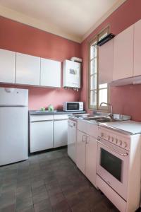 una cucina con elettrodomestici bianchi e una parete rossa di MERCALLI III a Milano
