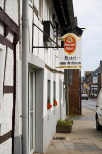 a sign for a hotel on the side of a building at Hotel zum Schwan Weilerswist in Weilerswist