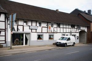 ein weißer Van vor einem Gebäude geparkt in der Unterkunft Hotel zum Schwan Weilerswist in Weilerswist