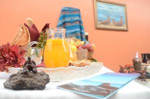 un tavolo con un piatto di cibo e un bicchiere di succo d'arancia di Hostal La Posada De Jose Carlos a Puerto Baquerizo Moreno