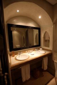 a bathroom with two sinks and a large mirror at Riad Dar Haven in Tamraght Ou Fella