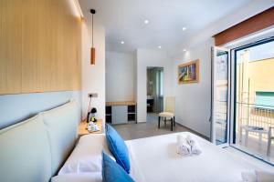 una camera con un letto bianco e una grande finestra di Maison Manfredi Sorrento a Sorrento