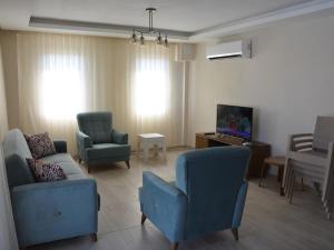 un salon avec des chaises bleues et une télévision dans l'établissement Konak Sari, à Dalyan