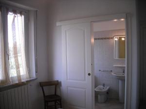 a white bathroom with a toilet and a sink at Paladini Apartment 1st Floor in Massa