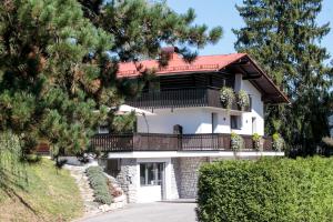 a house with a balcony on the side of it at Hiša Poljana Rooms in Prevalje