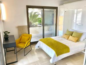 1 dormitorio con cama, escritorio y silla amarilla en Agence AICI - Appartements Gray d'Albion, en Cannes