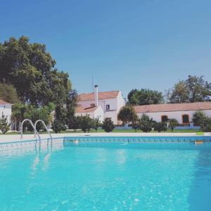 a swimming pool with blue water in front of a building at Quinta da Varzea in Raposa